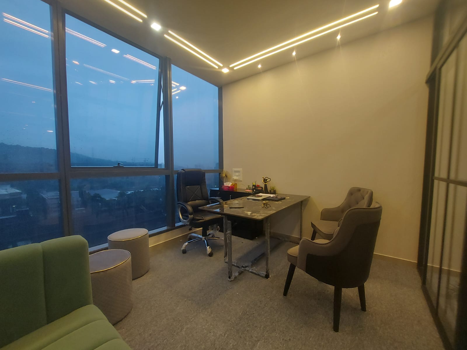 Executive suite office with full-height windows and integrated ceiling lighting