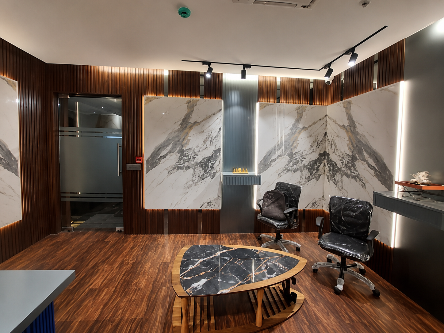 Executive suite with timber wall panelling, marble features and integrated lighting by MEMAAR